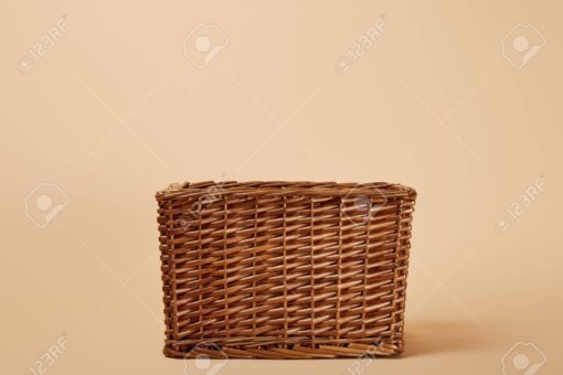 natural brown wicker basket on beige background
